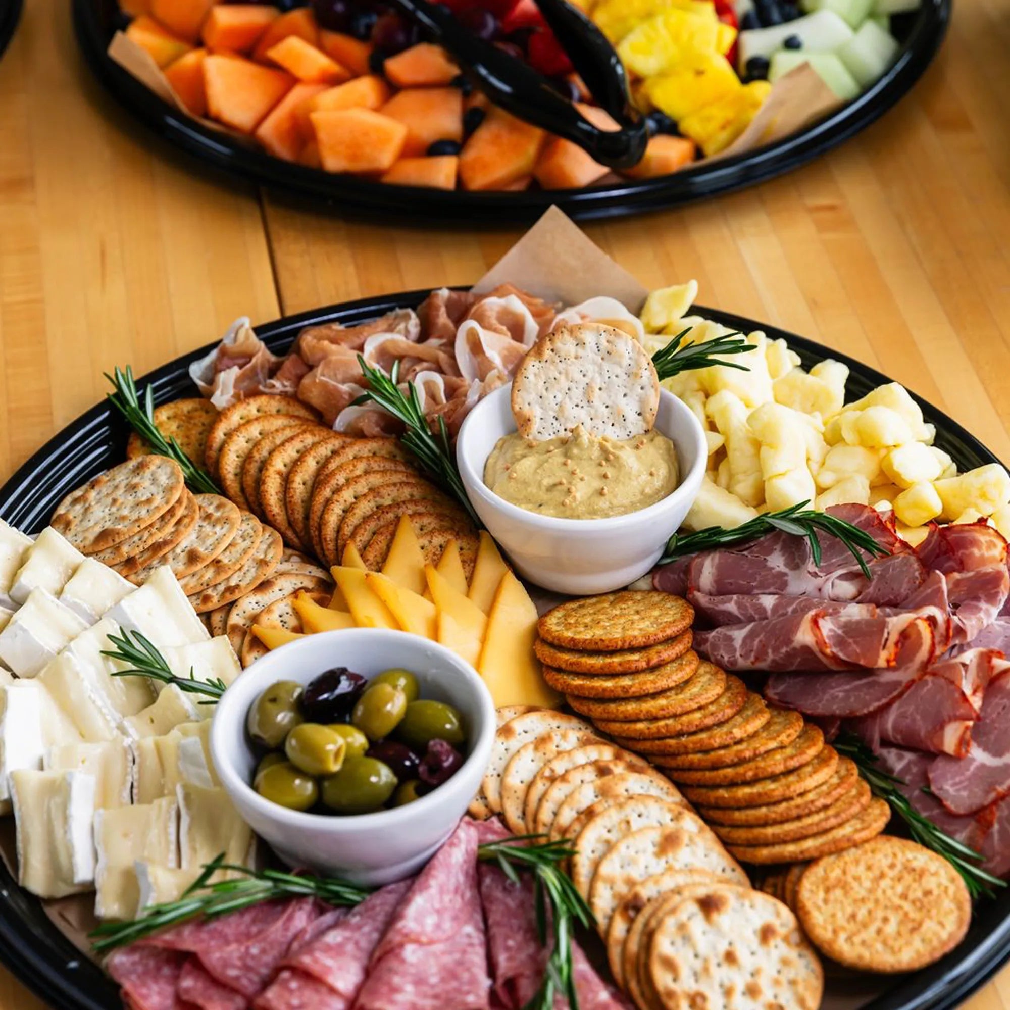 Messenger Catering menu items featuring a charcuterie tray with crackers, olives, cheeses and meats.