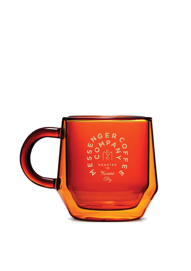 Amber Mug: Double-walled glass coffee mug with glowing amber finish and Messenger logo, displaying elegant translucent glow
