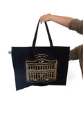 Flagship Tote Bag with gold storefront illustration on black canvas, featuring Grand Blvd cafe design and black handles